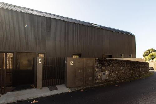 a black building with two doors and a fence at Dark Studio in São Roque
