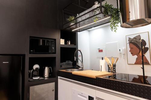 a kitchen with a counter top with a sink and a microwave at Dark Studio in São Roque