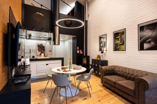 a living room with a couch and a table and chairs at Dark Studio in São Roque