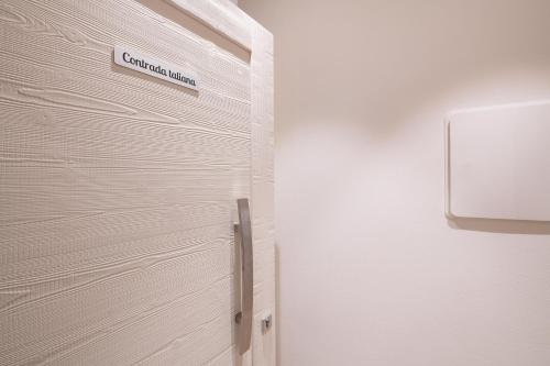 a door with a sign on it next to a wall at Palazzo Chimelli in Pergine Valsugana