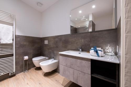 a bathroom with a sink and a toilet and a mirror at Palazzo Chimelli in Pergine Valsugana