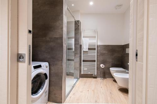 ein Badezimmer mit einer Waschmaschine und einem WC in der Unterkunft Palazzo Chimelli in Pergine Valsugana