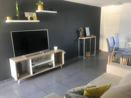 sala de estar con TV de pantalla plana en un centro de entretenimiento en Habita Plaza -Dpto en Barrio General Paz con Pileta Sum en Córdoba