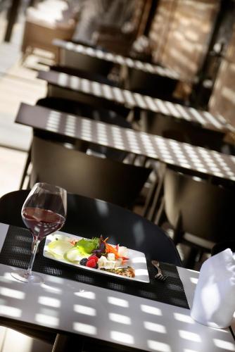 a plate of food and a glass of wine on a table at HCC St. Moritz in Barcelona