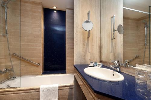 a bathroom with a sink and a tub and a shower at HCC St. Moritz in Barcelona