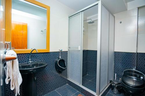 a bathroom with a glass shower and a sink at Departamento KIRI familiar ó empresarial cerca al Aeropuerto de Juliaca- Perú in Juliaca