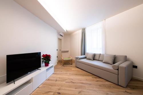 a living room with a couch and a flat screen tv at Palazzo Chimelli in Pergine Valsugana
