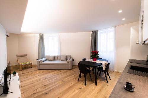 a living room with a table and a couch at Palazzo Chimelli in Pergine Valsugana