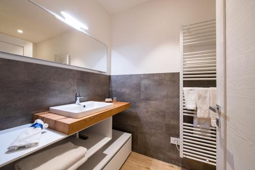 ein Bad mit einem Waschbecken und einem Spiegel in der Unterkunft Palazzo Chimelli in Pergine Valsugana