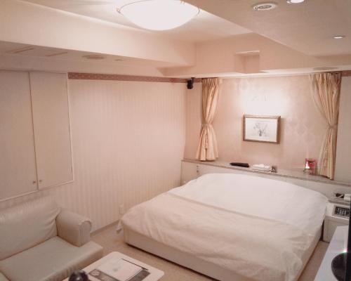 a bedroom with a white bed and a couch at ＳＴＡＲＲＥＳＯＲＴ　Ｉ in Sayama