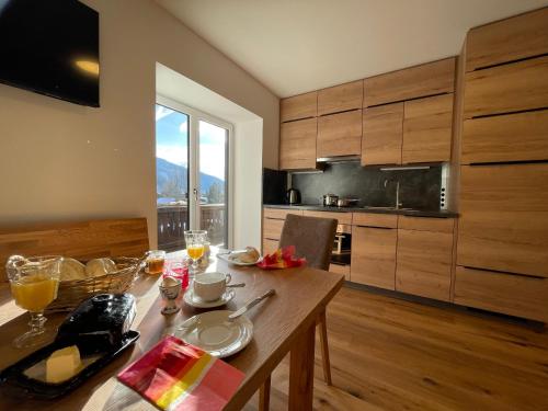 una cocina con una mesa de madera con comida. en appartementsKOFLER, en Mallnitz