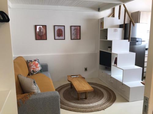 a living room with a couch and a tv at Tiny House Jeri in Jericoacoara