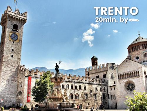 a large building with a clock tower and a fountain at Palazzo Chimelli in Pergine Valsugana
