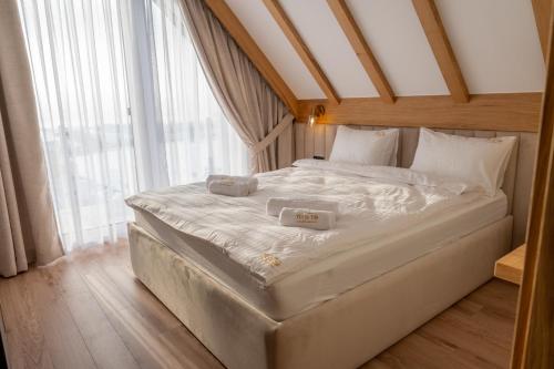 un grande letto bianco in una stanza con finestra di To Je To apartamenty a Maniowy