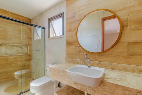a bathroom with a sink and a mirror and a toilet at SA07 Maravilhosa Casa 5 Suítes - Reserva de Sauípe in Costa do Sauipe