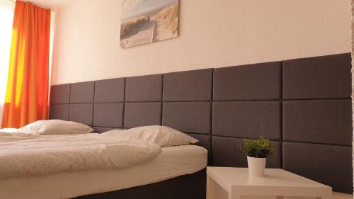sypialnia z czarnym zagłówkiem i łóżkiem w obiekcie Workers-Sleep-Station w Kolonii