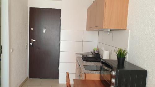 a kitchen with a black door and a black microwave at Workers-Sleep-Station in Cologne