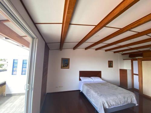 1 dormitorio con 1 cama en una habitación con ventana en Beautiful apartment in the heart of Puerto Ayora, en Puerto Ayora