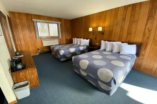 een hotelkamer met 2 bedden en houten wanden bij Waterway Inn in Indian River