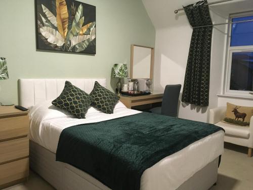 1 dormitorio con cama, escritorio y ventana en Clune House B&B en Newtonmore