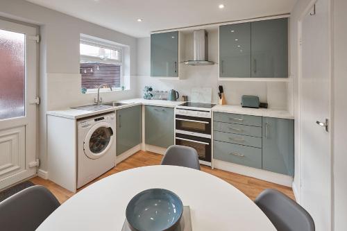 a kitchen with a table and a washing machine at Host & Stay - Station Cottage in Saltburn-by-the-Sea