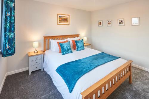 a bedroom with a large bed with blue pillows at Host & Stay - Station Cottage in Saltburn-by-the-Sea
