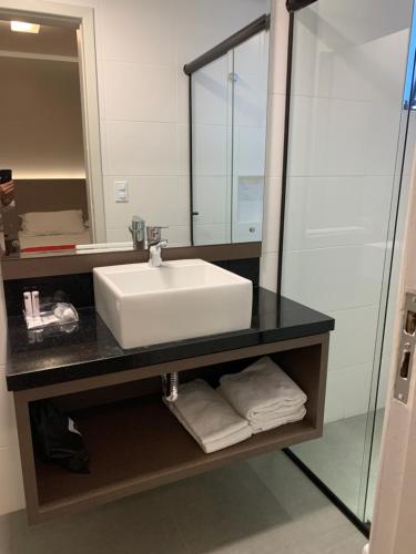 a bathroom with a sink and a mirror at Hotel Farol da Ilha in Florianópolis