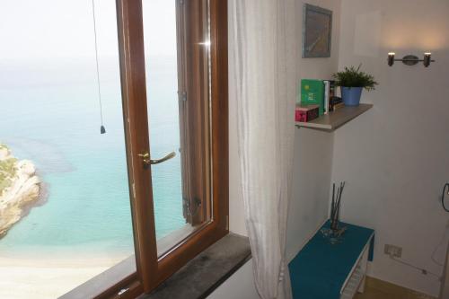 Cette chambre dispose d'une fenêtre offrant une vue sur l'océan. dans l'établissement BlueMind, à Tropea