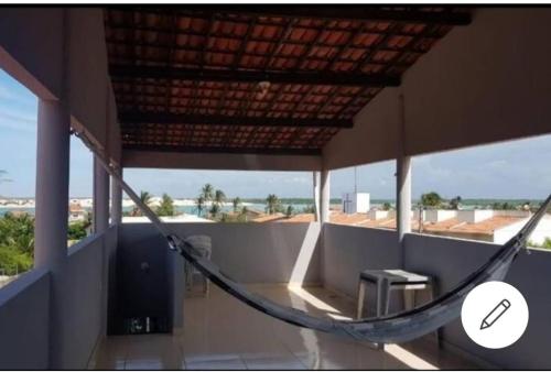 a hammock on a balcony with a view of the ocean at Ilha do amor in Camocim