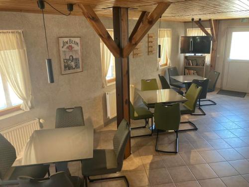 ein Restaurant mit grünen Stühlen und Tischen in einem Zimmer in der Unterkunft FARKAS VENDÉGHÁZ in Sopron