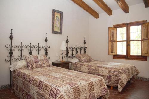 1 dormitorio con 2 camas y ventana en Mas de Paco, Chimenea, barbacoa y piscina en Vall dʼAlba