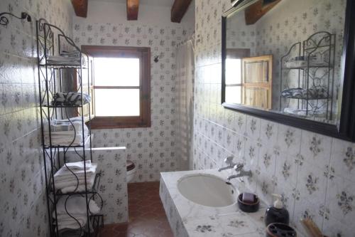 baño con lavabo, espejo y estante en Mas de Paco, Chimenea, barbacoa y piscina en Vall dʼAlba