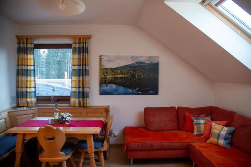 Sankt Andrä im LungauにあるFerienwohnung Seifterhofのリビングルーム(赤いソファ、テーブル付)