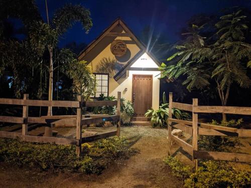 ein Haus mit einem Zaun davor in der Unterkunft Didi Lodge - Cabaña cálida y acogedora! in Cañas