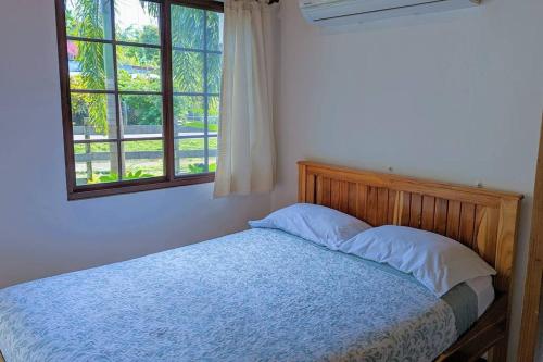 a bed in a bedroom with a window at Didi Lodge - Cabaña cálida y acogedora! in Cañas