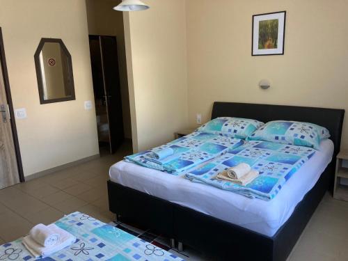 a bedroom with a bed with blue and white sheets at FARKAS VENDÉGHÁZ in Sopron