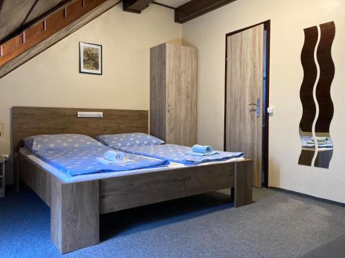 um quarto com uma cama com lençóis azuis e uma porta em FARKAS VENDÉGHÁZ em Sopron