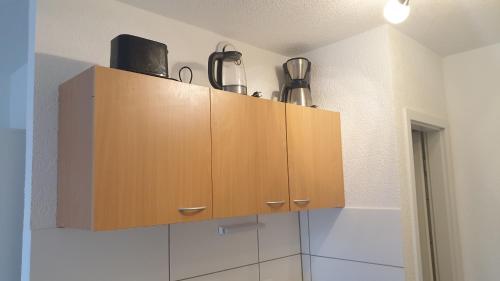 a kitchen with wooden cabinets with appliances on top at Workers-Sleep-Station in Cologne