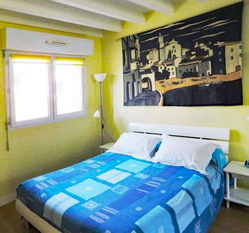 um quarto com uma cama com um quadro na parede em Lodge Mendia em Anglet