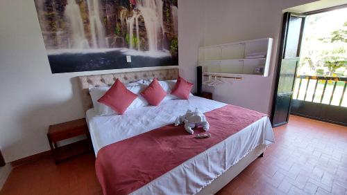 a bedroom with a teddy bear sitting on a bed at HOTEL BOUTIQUE SIMACOTA in Simacota