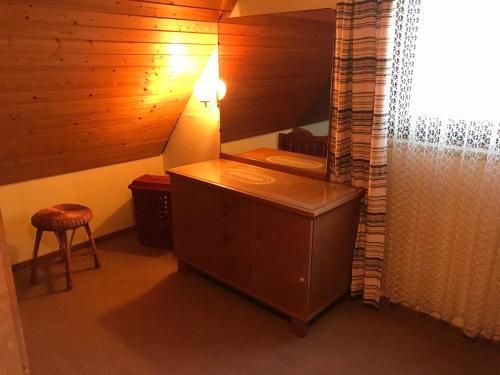 Zimmer mit einer Kommode, einer Lampe und einem Stuhl in der Unterkunft Retro Ferienwohnung mit Schlossblick im Nordschwarzwald in Altensteig