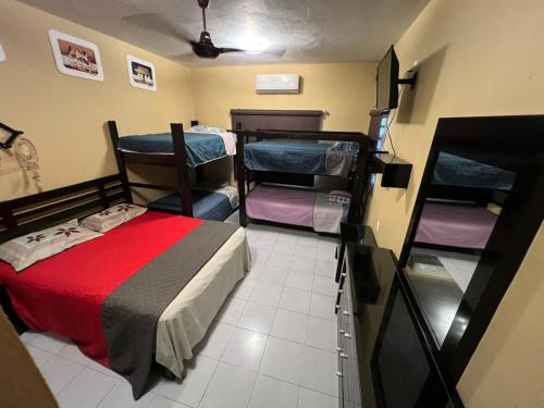 a room with a bed and two bunk beds at Casa paloma cerca de centro comercial y AirPort in Chetumal