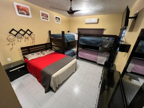 a bedroom with a bed and a red blanket at Casa paloma cerca de centro comercial y AirPort in Chetumal