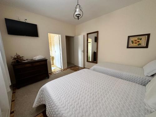 a bedroom with a bed and a television on the wall at Deck Hospedaria in Cunha