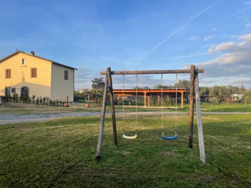 an empty swing set in a field with a house at L'Acero di STALL in Viterbo