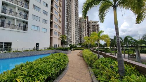 a pathway with palm trees and a swimming pool at Circulo Verde Avila North Tower in Manila