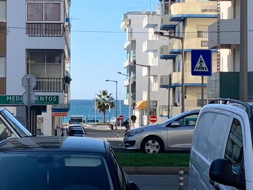 a street with cars parked on a street with buildings at Eine Wohnung für den perfekten Urlaub !!! in Quarteira