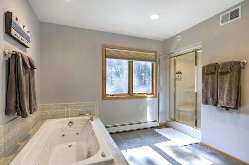 a bathroom with a large tub and a shower at Swim, Hike, Relax Lakefront Hayward Home with Deck! in New Post