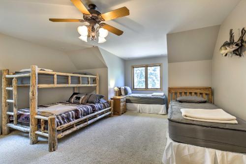 a bedroom with two bunk beds and a ceiling fan at Swim, Hike, Relax Lakefront Hayward Home with Deck! in New Post