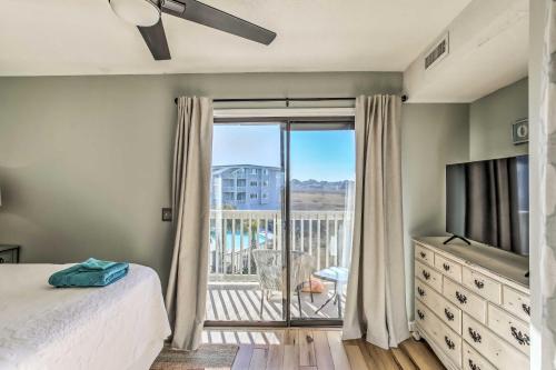 Schlafzimmer mit einem Bett, einem TV und einem Balkon in der Unterkunft Condo with Pool Access - Walk to Beach! in Carolina Beach